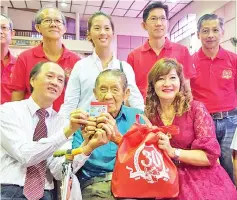  ??  ?? Yong (seated left) presenting the Sports Toto Chinese New Year Angpao donation to 102-year-old Chin Kon Tshin, who was among 400 senior citizens receiving the goodies at Dewan Foo Chow yesterday.