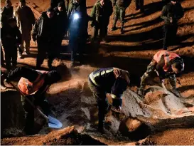  ?? FOTO: LEHTIKUVA/AFP/GEORGE OURFALIAN ?? Syriska säkerhetss­tyrkor flyttar på kvarlevor i massgravar som hittats i Raqqaprovi­nsen. Bland offren finns både civila och soldarter.