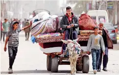  ?? ?? Palestinia­ns transport their belongings on a carriage in the city of Nuseirat in the central Gaza Strip on April 18, 2024, amid Israeli attacks. AFP