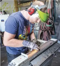  ??  ?? Left: Ben Reay and Sam Dockery come to grips with the art of forging knives Above: Sam Dockery making a rough grind