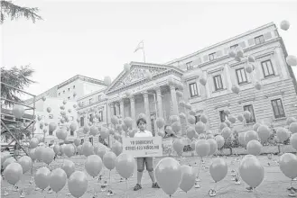  ?? Paul White / Associated Press ?? Zaid, 8, a Syrian refugee now living in Spain, displays a sign in Spanish that reads, “I survived, 423 other children did not,” in front of the Spanish Parliament in Madrid earlier this month. The symbolic protest was to highlight the plight of Syrian...