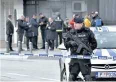  ?? RISTO BOZOVIC/ THE ASSOCIATED PRESS ?? A police officer guards the U. S. Embassy in Montenegro’s capital Podgorica, on Thursday after a man threw an explosive device into the U. S. Embassy compound before killing himself.