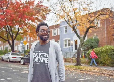  ??  ?? Pearson, who served in the Army from 1990 to 1999, looks out into his neighbourh­ood in front of his rowhouse.