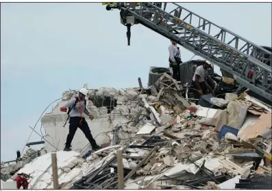  ?? (AP/Lynne Sladky) ?? Rescuers search the rubble of a collapsed wing of the beachfront condo Thursday outside Miami. Teams of 10-12 rescuers at a time entered the rubble with dogs and equipment, working until they grew tired from the heavy lifting, the state’s fire marshal said.