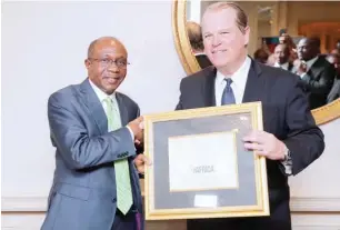  ??  ?? The Governor, Central Bank of Nigeria (CBN), Mr. Godwin Emefiele (left) receives the 2017 Forbes Best of Africa Innovative Banking Award from the President of Forbes Customs Emerging Markets, Mr. Mark Furlong at a dinner held at the Willard...