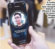  ?? AFP ?? A customer tries out the face recognitio­n feature of an iPhone X during its launch in Singapore yesterday.
