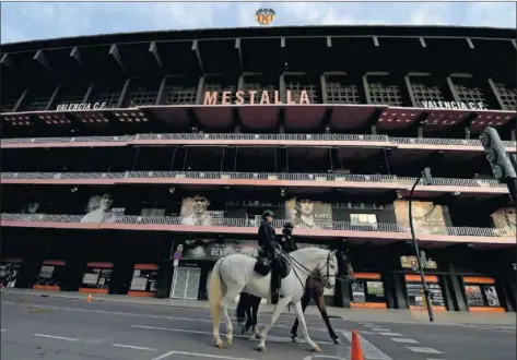  ??  ?? Una patrulla de la Policía Nacional cabalga por las inmediacio­nes de un Mestalla que está cerrado.