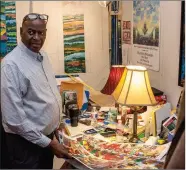  ?? (Arkansas Democrat-Gazette/Cary Jenkins) ?? Henri Linton with printed studies of a large painting in his Pine
Bluff studio