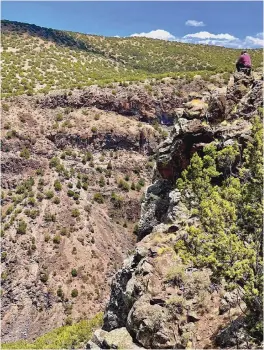  ?? COURTESY OF GARRETT VENEKLASEN ?? Julian Gonzales, a local resident, rancher and hunter, sits on an escarpment overlookin­g the Rio Grande. Los Alamos National Laboratory wants to string highvoltag­e power lines across the river to meet future power needs.