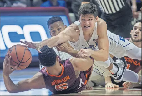  ?? [DON PETERSEN/THE ASSOCIATED PRESS] ?? Duke’s Grayson Allen, top, dives for a loose ball against Virginia Tech’s Justin Robinson during the first half of the Hokies’ upset of the No. 5 Blue Devils.NO. 6 KANSAS 80, TEXAS 70: