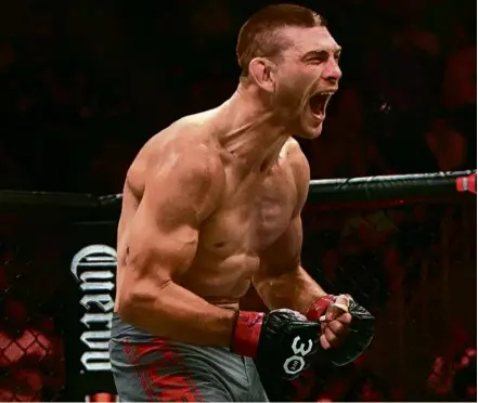  ?? BARRY CHIN/GLOBE STAFF ?? Kurt Holobaugh celebrates after submitting Austin Hubbard with a triangle choke hold at UFC 292.