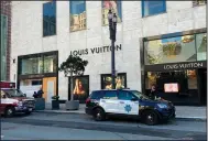  ?? (AP/San Francisco Chronicle/Danielle Echeverria) ?? Police officers and emergency crews park outside the Louis Vuitton store in San Francisco’s Union Square on Sunday after looters ransacked businesses late Saturday night.