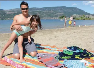  ?? STEVE MacNAULL/The Daily Courier ?? Thanh Pham and his daughter, Isabella, 5, enjoy Tugboat Bay Beach, which has reopened.