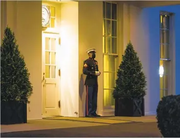  ?? DOUG MILLS THE NEW YORK TIMES ?? A Marine guard stands post outside the West Wing of the White House in Washington on Monday, indicating that President Donald Trump is in the Oval Office. Trump stayed out of public view on Monday.