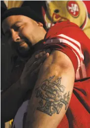 ??  ?? Left: Antonio Garcia shows his 49ers tattoo at a gathering on Alabama Street in the Mission.