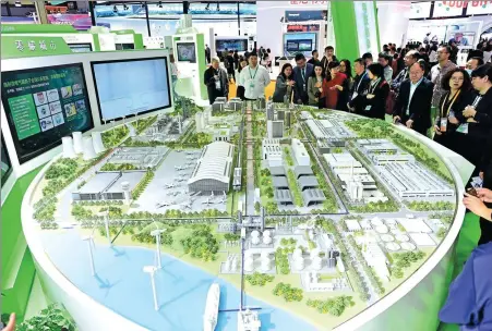  ?? TIAN YUHAO / CHINA NEWS SERVICE ?? Visitors are at the zero-carbon city sand table at the exhibition stand of Schneider Electric SE during the 6th China Internatio­nal Import Expo in Shanghai on Nov 7.