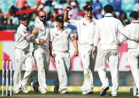  ?? Reuters ?? Nathan Lyon (second from left) celebrates with Australian teammates after dismissing Indian captain Ajinkya Rahane during the second day of the fourth and final Test in Dharamsala. The off-spinner has claimed four of India’s six wickets to fall...