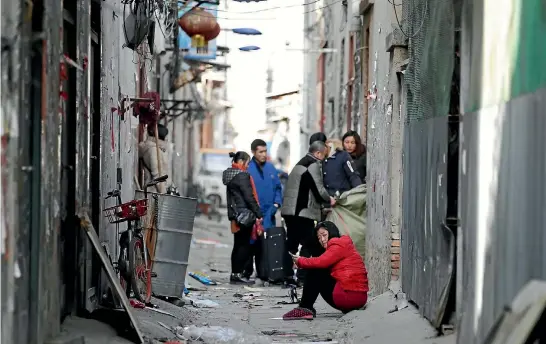  ?? PHOTOS: REUTERS ?? Migrant workers leave their homes after being evicted because of a city-wide fire safety inspection.