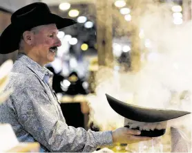  ?? Karen Warren / Staff photograph­er ?? Keith Brownell steams a hat for a customer at the Cavender’s booth at the Houston Livestock Show and Rodeo in NRG Center.