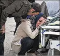  ?? FARZAD MENATI / TASNIM NEWS AGENCY ?? A relative weeps over the body of an earthquake victim
Monday in Sarpol-eZahab. The city appeared to have the worst damage from the quake.