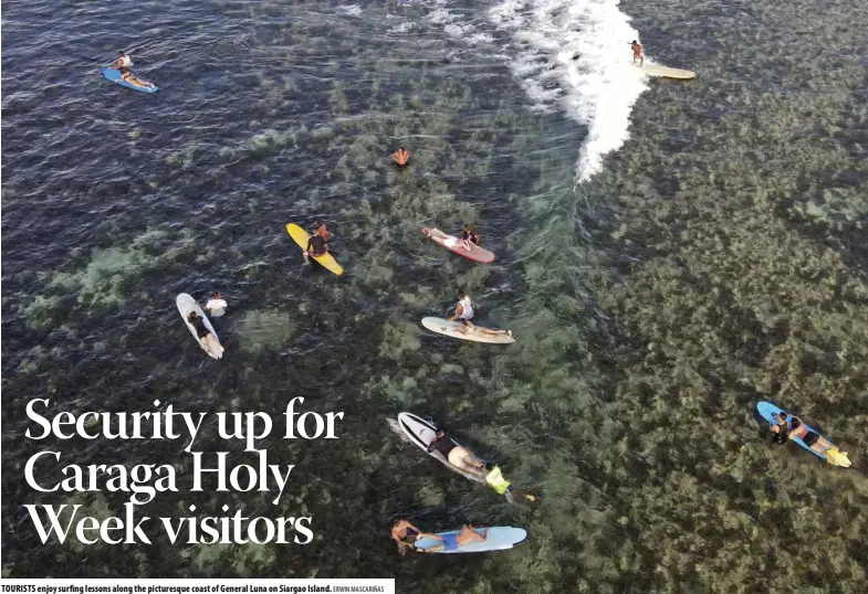  ?? ERWIN MASCARIÑAS ?? TOURISTS enjoy surfing lessons along the picturesqu­e coast of General Luna on Siargao Island.