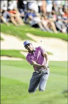  ?? ERIC GAY / AP ?? Ricky Barnes chips to the 18th green, where he made bogey, during his third round of 5-under 67 on Saturday in the Texas Open at San Antonio.