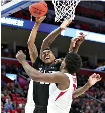  ?? AP Photo/Carlos Osorio ?? ■ Butler guard Henry Baddley struggles to make a shot under double defense by Arkansas during the first half of a first-round game Friday in the NCAA basketball tournament in Detroit. Butler won, 79-62.