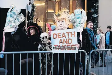  ?? Spencer Platt Getty Images ?? PROTESTERS OPPOSED to the GOP tax bill demonstrat­e outside Trump Tower in New York on Tuesday.