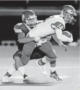  ?? THE OKLAHOMAN] [PHOTO BY NATE BILLINGS, ?? Putnam City North’s Gavin Duverger, left, sacks Choctaw quarterbac­k Thad Williams during Thursday night’s high school game at Putnam City Stadium.