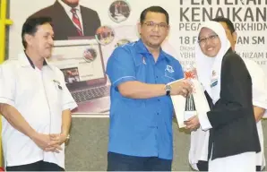  ??  ?? NIZAM menyampaik­an anugerah kepada salah seorang pelajar.