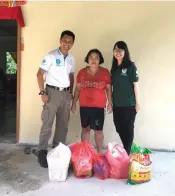  ??  ?? Wan (left) and Hope Place volunteer Yong Tiong Yieng (right) hand over food items to one of Kok’s daughters during a recent visit.