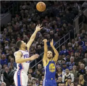  ?? CHRIS SZAGOLA — THE ASSOCIATED PRESS ?? Golden State’s Stephen Curry (30) shoots a 3-pointer as Simmons left, defends during the first half. the 76ers’ Ben