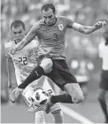  ??  ?? Uruguay’s Diego Godin, right, attempts to control the ball against Russia’s Artyom Dzyuba on Monday.