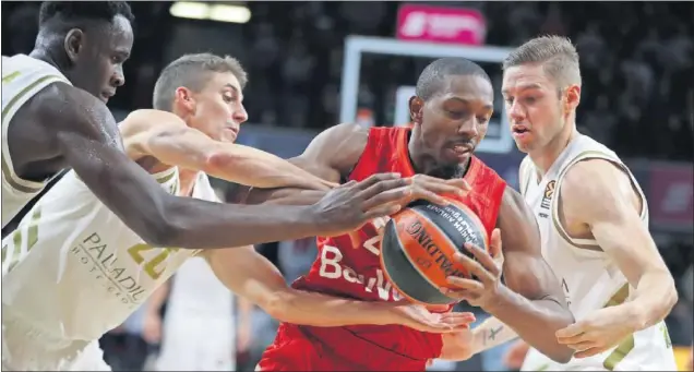  ??  ?? Usman Garuba, Jaycee Carroll y Fabien Causeur, jugadores del Real Madrid, tratan de arrebatarl­e el balón a DeMarcus Nelson, del Bayern Múnich.