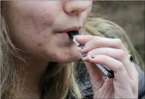  ?? STEVEN SENNE — THE ASSOCIATED PRESS FILE ?? A high school student uses a vaping device near a school campus in Cambridge, Mass.