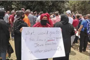  ?? (AFP) ?? A woman holds up a sign against Israel’s controvers­ial Citizenshi­p and Entry law, during a demonstrat­ion by Israeli Arabs, outside the Knesset building in Jerusalem on Monday.