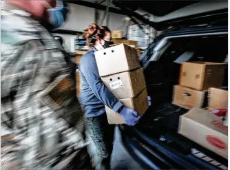  ?? STAFF PHOTO ?? The Foodbank employee Abby Bishop loads vehicles on Armore Place lastmonth. The recent increase in COVID-19 cases has caused a second large demand for food in Dayton.