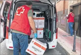  ??  ?? Voluntario­s de la Cruz Roja reparten productos básicos a domicilio.