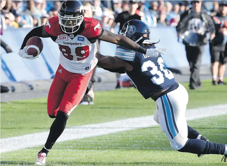  ?? — THE CANADIAN PRESS ?? Stampeders receiver DaVaris Daniels eludes Toronto Argonauts defensive back Thomas Gordon for a touchdown during a 48-20 win in Toronto Monday.