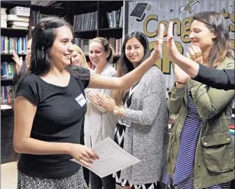  ?? Lawrence K. Ho Los Angeles Times ?? MONICA ROMERO high-fives volunteers after completing a 16-week course that helps young adults with autism, who often have trouble reading the emotions of others, navigate social interactio­ns.