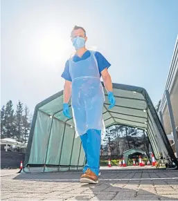  ?? Pictures: Steve MacDougall. ?? Top: Healthcare assistant Mike Boyle, left, and Dr Nico Grunenberg set up the new assessment hubs. Above: Dr Grunenberg at the line of hubs.