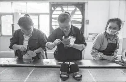  ?? GILLES SABRIE / THE NEW YORK TIMES ?? Employees make shoes in December 2016 on the assembly line at the Huajian Gongguan shoe factory, which produces heels for Ivanka Trump’s line of shoes, in Dongguan, China. Hua Haifeng’s arrest in May at the factory, which he was investigat­ing...