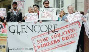  ?? — Reuters ?? Protesters display a banner and posters in front of the venue of commoditie­s trader Glencore’s annual shareholde­r meeting in Zug, Switzerlan­d.