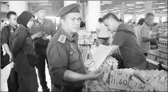  ??  ?? The ministry’s Sibu branch deputy chief Ganda Jirap and his personnel at one of the egg stalls in Sibu Central Market.