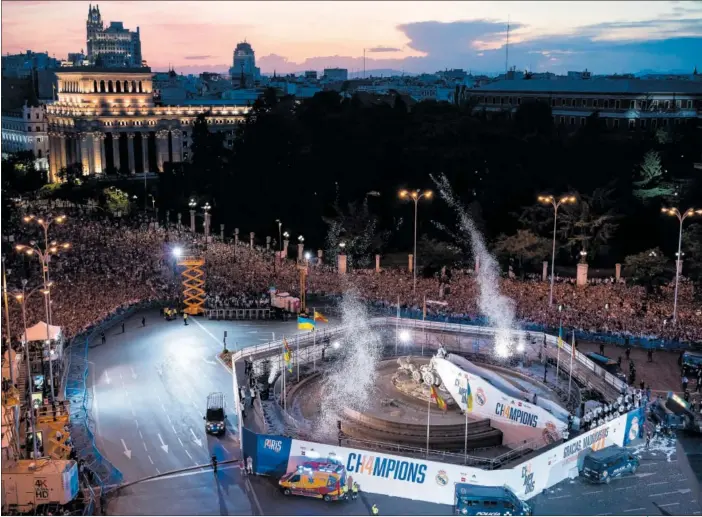  ?? ?? Panorámica de la plaza de Cibeles abarrotada de gente durante la celebració­n de los jugadores, con el edificio que alberga la sede del Instituto Cervantes iluminado al fondo.