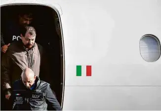  ?? Alberto Pizzoli -14.jan.19/afp ?? Cesare Battisti é escoltado por policiais ao chegar no aeroporto de Roma