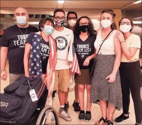  ?? Gil Torres / Contribute­d photo / ?? Matthew Torres (center with flag mask) is welcomed home from the 2020 Paralympic­s by his dad, Gil, (far left) and mom, Martha (right of Matthew in black mask) along with close friends at the Newark Liberty Internatio­nal Airport in New Jersey. Matthew won a bronze medal at the 2020 Summer Games in the 400-meter S8 freestyle.