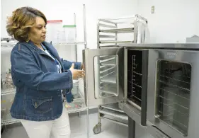  ?? KYLE TELECHAN/POST-TRIBUNE PHOTOS ?? Sybil Peeples, Hammond Developmen­t Corp. Community Kitchen manager, points out a commercial-scale convection oven during a walk-through of the facility on Thursday.