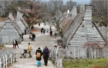  ?? Steven Senne / Associated Press ?? Visitors walk through Plimoth Plantation, a living history museum village where they can get a glimpse into the world of the 1627 Pilgrim village in Plymouth, Mass.