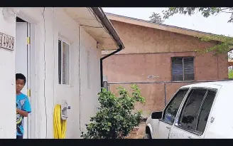  ?? SOURCE: ALBUQUERQU­E POLICE DEPARTMENT ?? In this police lapel camera photo taken in June 2013, six months before his murder, Omaree Varela peeks out of a door of his residence while Albuquerqu­e police officers leave the scene. They had responded to a 911 call at the home.